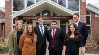Six members of Saint Lawrence University's student government organization, Thelmo, stnad outside the Diana B. Torrey Health and Counseling Center. 