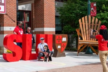 Family poses with SLU letters in front of the Sullivan Student Center