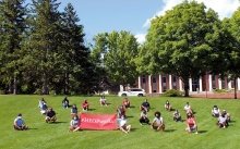 Students sitting on the grass with HEOP sign