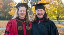 President Kathryn Morris and Jennifer Curley Reichert wearing academic regalia. 