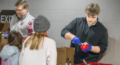 Connor Simons '28 serving scoops of Pub Cookie Crunch to local hockey fans at the Route 11 Rivalry game