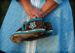 A woman holding traditional Mohawk shoes