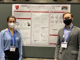 A student and faculty member stand in front of a chemistry research poster at a conference.