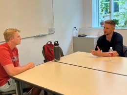 two men sitting at a table having a discussion