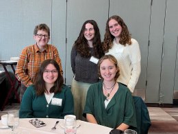 female professor with her four female students posing for picture