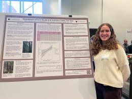 female student smiling presenting her poster