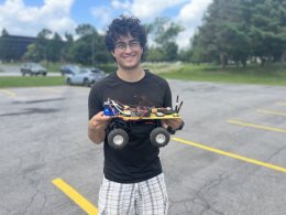 Cai Lemieux Mack '23 holds autonomous rover during his research