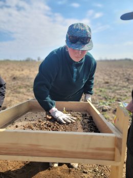 Student sifting at burial ground