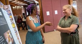 Sarath Novas discusses her research presentation with Professor Sara Ashpole.