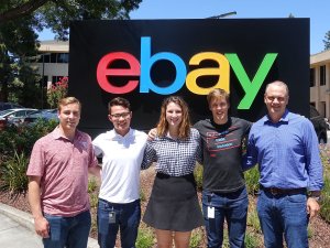 Four Saint Lawrence University students stand with an alumni mentor in front of the ebay sign.