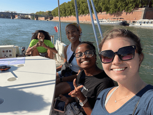 Four Saint Lawrence students smile big while on a boat in France.