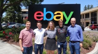 Four Saint Lawrence University students stand with an alumni mentor in front of the ebay sign.