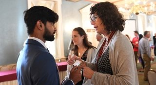 A Laurentian hands their business card to a student during a networking reception.