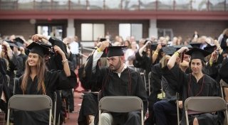 Rows of Saint Lawrence University graduates move their tassles from right to left at Commencement.