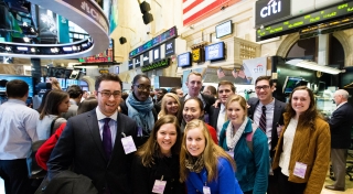A group of students stand among the crowd at the New York Stock Exchange. 