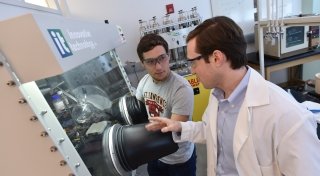 A Saint Lawrence student and a professor perform and experiment in a chemistry lab.
