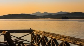 Upper Saranac Lake as the sunsets over blue mountains.