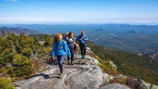 Three people walking on a mountain