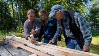 Students working with craftsman on wood project