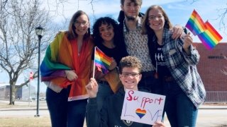 A group of five Saint Lawrence students holding rainbow flags at the Potsdam Pride March. 