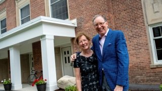 Bill and Lynn Fox stand in front of the newly named Fox Hall.