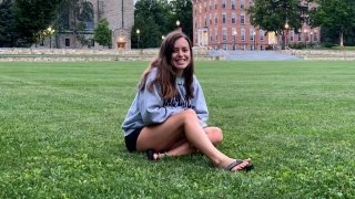 A Saint Lawrence student sits on the quad on a quiet night on campus.