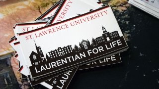 A stack of bumper stickers with "Laurentian for Life" and the Saint Lawrence University skyline on them.