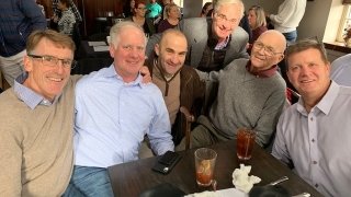 Don Leet is seated with a group of six of his former athletes.