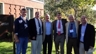 Group stands in from of building.