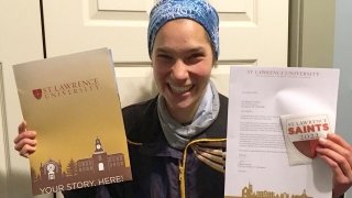Meg Charles, holding a Saint Lawrence acceptance folder and letter. 