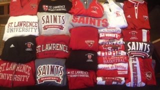Scarlet, grey, and brown Saint Lawrence sweatshirts and jackets on a table. 