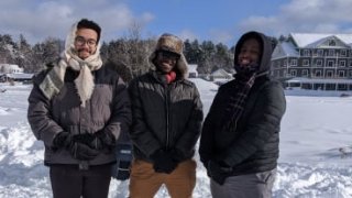 Three Saint Lawrence students stand outside in the snow at the annual Winter Carnival Event in Saranac Lake, NY.