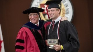 President Emeritus Fox poses with Matt Ramm ’20 at Commencement.