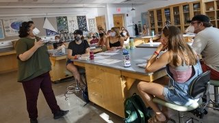 Aswini Pai, a biology professor, teaches a masked biology class attended by several engaged students.
