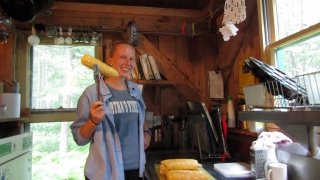Lauren smiling next to freshly cooked corn.
