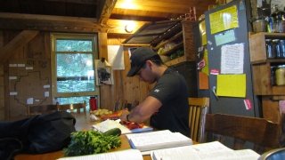 Robertson chopping vegetables, surrounded by cookbooks, in preparation for dinner.