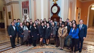 A group of Saint Lawrence University students, wearing business professional attend an alumni event in Washington, D.C. attire, 
