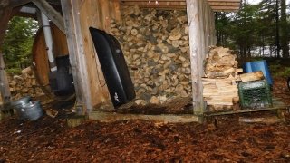 Seasoned logs lie by the sauna until an Arcadian sleds the logs to a mini wood shack.