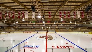 Banners hang from the rafters above the Saint Lawrence Hockey emblem on the ice of Appleton Arena. 
