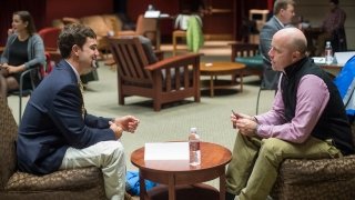 A Saint Lawrence University student, wearing professional attire, partakes in a mock interview with a Saint Lawrence University alumnus. 