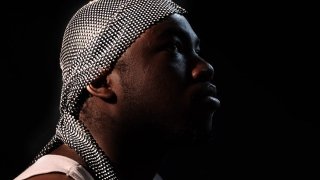 Black man in profile wearing a silver jeweled doormat