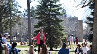 A photo of a professor teaching a group of students crowded in a circle on St. Lawrence's campus.