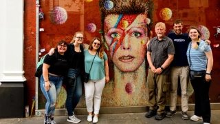 A photo of St Lawrence students standing outside of a David Bowie mural.
