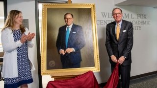 Saint Lawrence President Kathryn Morris and President Emeritus William Fox unveil Fox's presidential portrait.