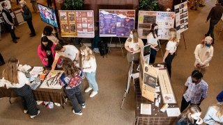 An aerial view of several students, presenting and exploring research posters about the origins of chocolate.