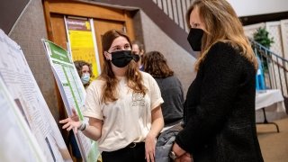 President Morris listens as a student enthusiastically explains their research project.