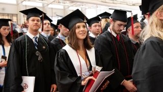 Members of the Class of 2022, wearing graduation regalia, eagerly look to the stage during this year's commencement ceremony.