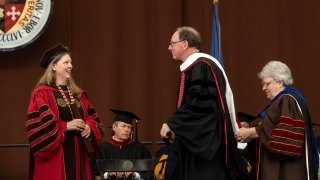 President Emeritus William Fox receives his doctorate hood as President Kathryn Morris offers words of congratulations.