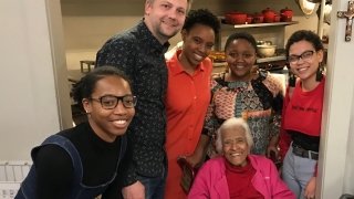A group of students gather for a photo with legendary New Orleans chef Leah Chase in her kitchen.