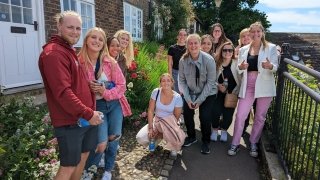 Students Stand Outside by Flowers